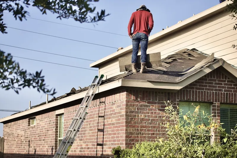 Professional roofer working on a residential roof in Bayport West